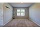 Carpeted bedroom showcasing a window with outside views and neutral walls at 237 Cranapple Ln, Mcdonough, GA 30253