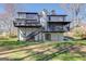 Expansive backyard view features a home with a multi-level deck, mature trees, and a lush lawn at 5284 Silver Creek Sw Dr, Lilburn, GA 30047