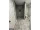 New gray tile shower with a neutral toilet and modern finishes at 5284 Silver Creek Sw Dr, Lilburn, GA 30047