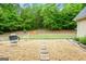 Large, well-maintained backyard featuring a stone paver patio with fire pit and chairs at 563 Deadwood Trl, Locust Grove, GA 30248