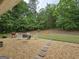 Large, well-maintained backyard featuring a stone paver patio with fire pit and chairs at 563 Deadwood Trl, Locust Grove, GA 30248