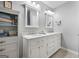 Bright bathroom with double vanity, marble countertop, white cabinetry, and linen closet at 563 Deadwood Trl, Locust Grove, GA 30248