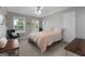Comfortable bedroom with two windows, ceiling fan and a view of mature trees at 563 Deadwood Trl, Locust Grove, GA 30248
