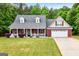 Charming single Gathering home, manicured lawn, inviting front porch, brick facade, and attached garage at 563 Deadwood Trl, Locust Grove, GA 30248