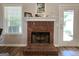 Inviting brick fireplace with a white mantel, perfect for cozy evenings at 563 Deadwood Trl, Locust Grove, GA 30248