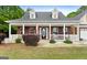 Inviting front porch featuring rocking chairs, an American flag, and well-maintained landscaping at 563 Deadwood Trl, Locust Grove, GA 30248