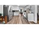 Open kitchen with stainless steel appliances, white cabinets, and wood-look flooring at 563 Deadwood Trl, Locust Grove, GA 30248