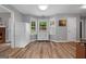 Eat-in kitchen area with bay windows, white cabinets, and wood-look floors at 563 Deadwood Trl, Locust Grove, GA 30248