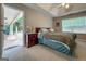 Carpeted main bedroom with a ceiling fan, ensuite bath, view to covered patio, and ample natural light at 563 Deadwood Trl, Locust Grove, GA 30248