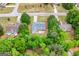 Aerial view of a tan, single-Gathering home featuring an outdoor living space, surrounded by lush trees in a quiet neighborhood at 563 Deadwood Trl, Locust Grove, GA 30248