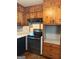 Kitchen features knotty pine cabinets with black appliances and brick-patterned flooring at 6576 Randall Mark Dr, Morrow, GA 30260