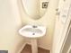 This bathroom features a white pedestal sink, round mirror, and neutral walls at 3311 Thornbridge Dr, Powder Springs, GA 30127