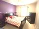This bedroom features purple accent wall, standard window, and traditional furnishings at 3311 Thornbridge Dr, Powder Springs, GA 30127
