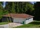 View of the gray-painted brick home, showcases its garage and partial yard with mature trees in background at 6286 Saddlewood Dr, Lithonia, GA 30058