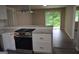 Bright kitchen showcasing granite countertops, stainless steel oven, modern vent hood, and gray plank flooring at 6286 Saddlewood Dr, Lithonia, GA 30058
