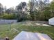 View of a backyard with a chain link fence, fire pit, shed, and forest in the background at 127 Jenny Rd, Grantville, GA 30220