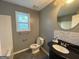 Bathroom with a black vanity, sink, toilet, tub, and window at 127 Jenny Rd, Grantville, GA 30220