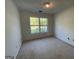Bedroom featuring neutral carpet, white walls, and a window providing natural light at 127 Jenny Rd, Grantville, GA 30220