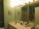 Bathroom with double sinks, large mirror, and neutral green paint at 25 Lake Charles Ct, Covington, GA 30016