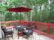 Outdoor deck with a table, chairs, an umbrella, and a view of the trees and forest at 25 Lake Charles Ct, Covington, GA 30016
