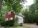 A red-brick home with an attached garage, featuring white trim, a driveway, and manicured bushes at 25 Lake Charles Ct, Covington, GA 30016