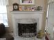 Close-up view of a marble fireplace with decorative mantel, screen, and built-in bookshelves at 25 Lake Charles Ct, Covington, GA 30016