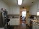 Well-lit kitchen with white cabinets, stainless-steel appliances, and tile floors for easy cleaning at 25 Lake Charles Ct, Covington, GA 30016