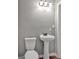 Half bathroom featuring white pedestal sink and standard toilet with silver hardware at 72 S Bethany Rd, Mcdonough, GA 30252
