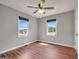 Sunlit bedroom featuring wood-look flooring, neutral walls, ceiling fan, and bright windows at 72 S Bethany Rd, Mcdonough, GA 30252