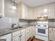 Bright kitchen featuring white appliances, granite countertops, and cream-colored cabinets for a classic look at 72 S Bethany Rd, Mcdonough, GA 30252