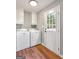 Well-lit laundry room boasts a modern washer and dryer and access to the backyard at 72 S Bethany Rd, Mcdonough, GA 30252