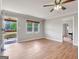 Bright, empty living room with wood-look floors, ceiling fan, and access to porch and other rooms at 72 S Bethany Rd, Mcdonough, GA 30252