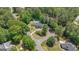 Beautiful aerial view of home on landscaped corner lot with mature trees, a pool, and circular drive at 12 Blackfoot Trl, Sharpsburg, GA 30277