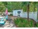 Charming backyard shed surrounded by lush greenery, white picket fence, and poolside lounge area at 12 Blackfoot Trl, Sharpsburg, GA 30277