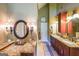 Bathroom vanity area with granite counters, dual sinks, and decorative sconces at 12 Blackfoot Trl, Sharpsburg, GA 30277