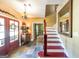 Warm and inviting foyer with hardwood floors, a staircase, and elegant lighting fixtures at 12 Blackfoot Trl, Sharpsburg, GA 30277