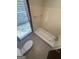 Cozy bathroom with toilet and bathtub featuring white tiled walls at 4081 Jodeco Rd, Stockbridge, GA 30281