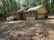 View of a two-story home featuring a brick facade and a side-entry garage nestled among trees at 4081 Jodeco Rd, Stockbridge, GA 30281