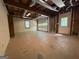 Unfinished garage featuring a roll-up door, utility access, and exposed beams and ductwork at 4081 Jodeco Rd, Stockbridge, GA 30281