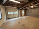 Unfinished garage featuring a roll-up door, utility access, and exposed beams at 4081 Jodeco Rd, Stockbridge, GA 30281