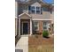 Charming two-story townhouse featuring a brick facade, a welcoming front porch, and a well-maintained landscaped yard at 6153 Oakley Rd, Union City, GA 30291