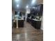 View of open kitchen with dark wood cabinets, island, hardwood floors, and stainless steel appliances at 6153 Oakley Rd, Union City, GA 30291