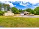 Expansive front yard with a two-story outbuilding and a charming single-Gathering home with an attached garage at 26 Cannongate Rd, Sharpsburg, GA 30277