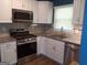 Modern kitchen featuring granite countertops, stainless steel appliances, and white cabinetry at 4616 Hamlet Se Walk, Conyers, GA 30094