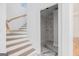 Hallway leading to stairs and a stylish bathroom with patterned wallpaper and marble flooring, a touch of elegance at 1620 Saddle Ridge Way, Sandy Springs, GA 30350