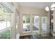 Bright dining area featuring a glass table and lots of natural light from several large windows overlooking the backyard at 1231 Hillview Rd, Hampton, GA 30228
