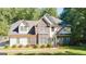 Beautiful home featuring stone and siding exterior, manicured lawn, and mature trees at 1231 Hillview Rd, Hampton, GA 30228