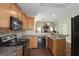 Efficient kitchen layout featuring breakfast bar, wood cabinets, and stainless steel appliances at 1231 Hillview Rd, Hampton, GA 30228
