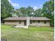 A spacious backyard features a concrete patio and lush lawn framed by mature trees at 110 Thompson Blvd, Stockbridge, GA 30281