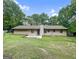Expansive backyard featuring a large grassy area, tree line, and the rear of the home with a patio at 110 Thompson Blvd, Stockbridge, GA 30281